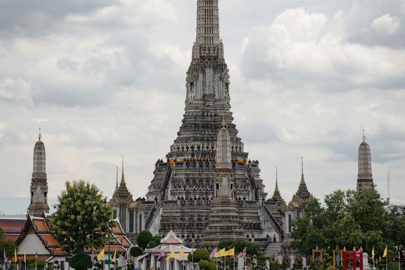 Tempel Wat Arun am Ufer des Chao Phraya in Bangkok mit einem Boot davor
