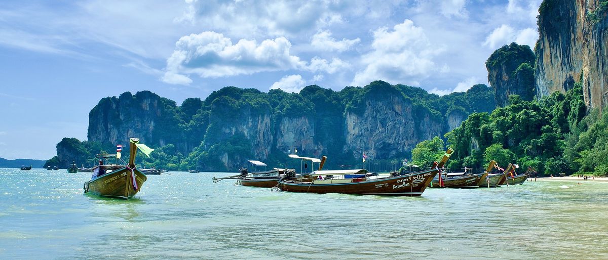 Longtail-Boote vor den Kalkfelsen am Railay Beach in der Provinz Krabi